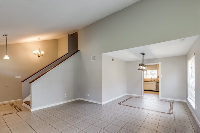 empty room with sink, light tile patterned floors, vaulted ceiling, and an inviting chandelier