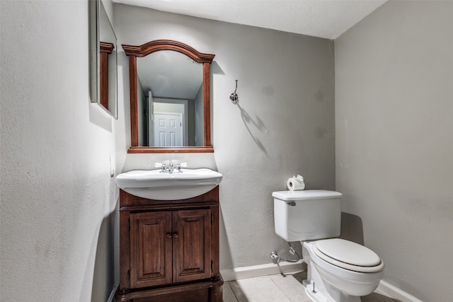 bathroom with tile patterned flooring, vanity, and toilet