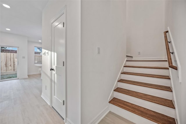 staircase featuring baseboards, wood finished floors, and recessed lighting