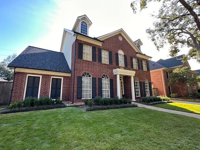 colonial home featuring a front lawn