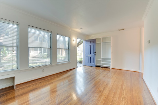 unfurnished room featuring light wood-type flooring and crown molding