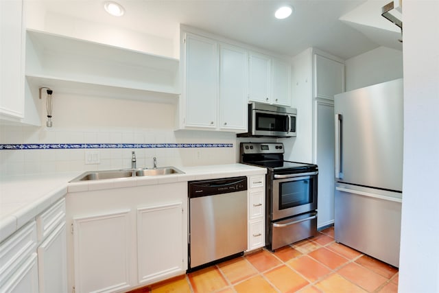 kitchen featuring backsplash, tile countertops, sink, and stainless steel appliances