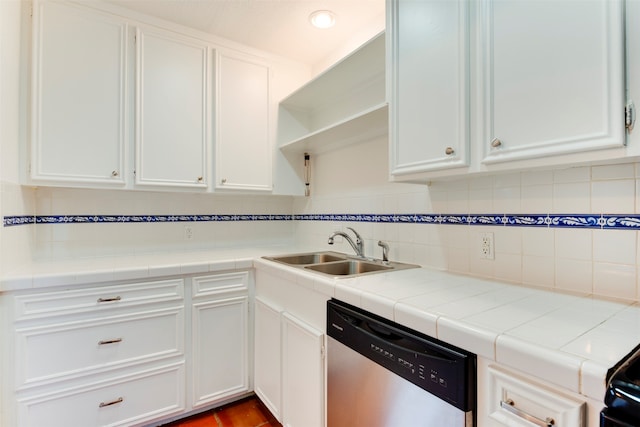 kitchen with tile countertops, white cabinetry, sink, and stainless steel dishwasher