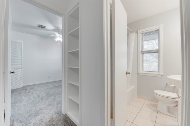 bathroom featuring tile patterned floors, shower / bath combination with curtain, ceiling fan, and toilet