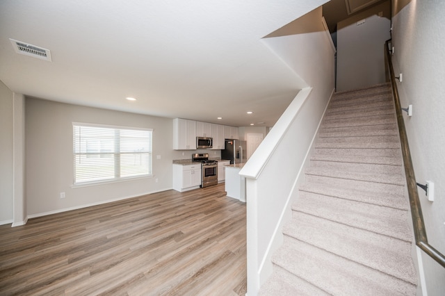 stairway with hardwood / wood-style floors