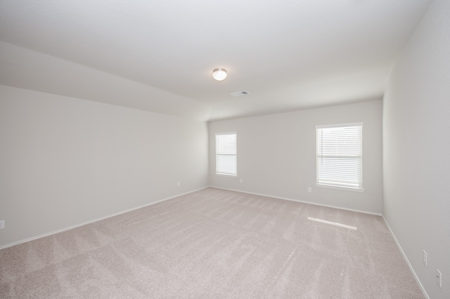 unfurnished room featuring light carpet