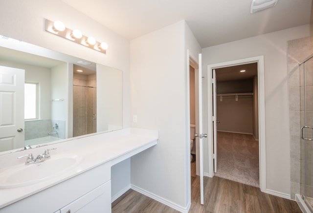 full bathroom with vanity, toilet, wood-type flooring, and shower with separate bathtub