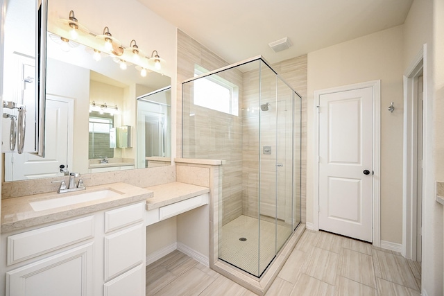 bathroom with a shower with door and vanity