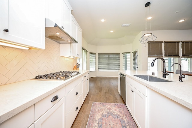 kitchen featuring pendant lighting, sink, appliances with stainless steel finishes, tasteful backsplash, and dark hardwood / wood-style flooring