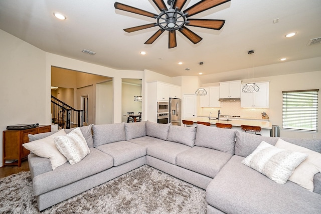 living room featuring ceiling fan, hardwood / wood-style floors, and sink