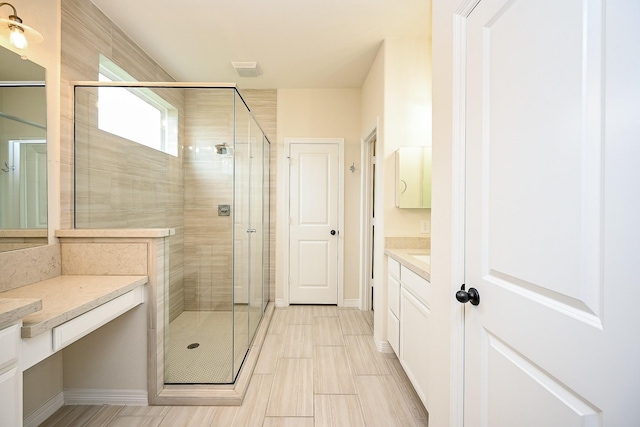 bathroom with vanity and a shower with shower door