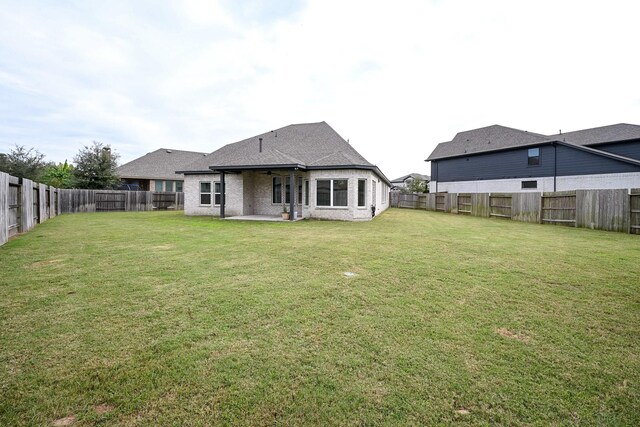 back of house with a lawn and a patio