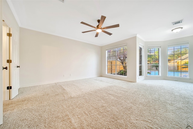 carpeted spare room with ceiling fan and ornamental molding