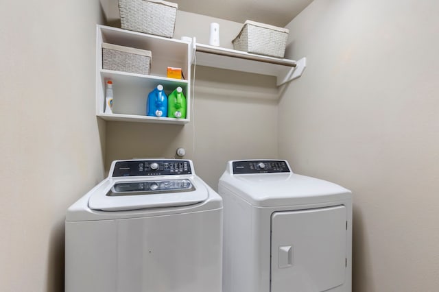 clothes washing area with washing machine and dryer