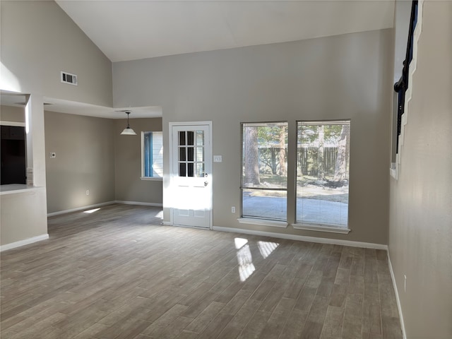 unfurnished living room with high vaulted ceiling and hardwood / wood-style flooring