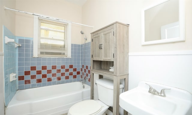 full bathroom with tiled shower / bath combo, toilet, and sink