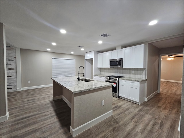 kitchen featuring sink, dark hardwood / wood-style flooring, a center island with sink, white cabinets, and appliances with stainless steel finishes