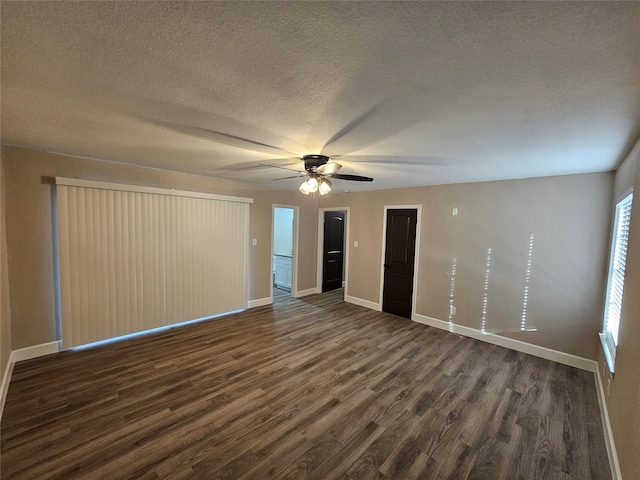 interior space featuring a textured ceiling, ceiling fan, and dark wood-type flooring