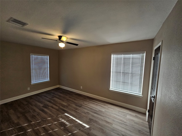 spare room featuring a textured ceiling, ceiling fan, and dark hardwood / wood-style floors