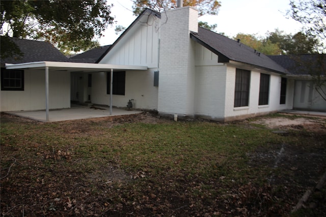 back of house with a lawn and a patio area