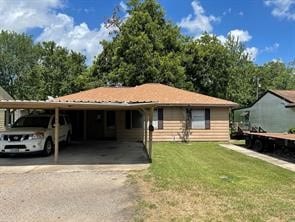 view of front of house featuring a carport and a front lawn