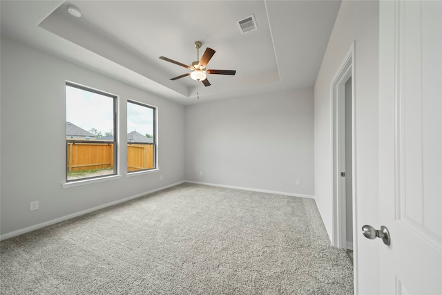 unfurnished room featuring carpet flooring, ceiling fan, and a tray ceiling