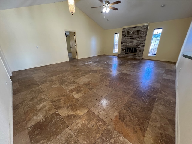 unfurnished living room featuring a fireplace, beamed ceiling, ceiling fan, and a healthy amount of sunlight