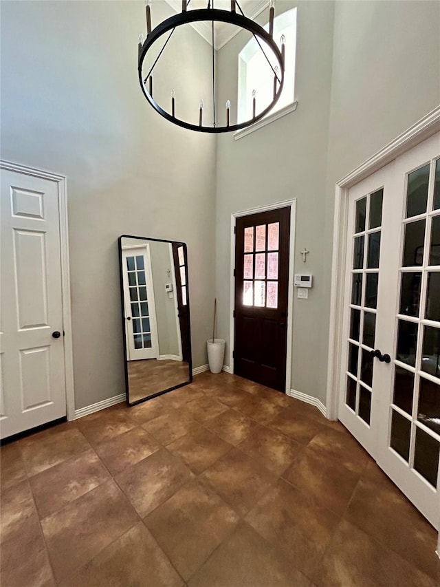 foyer featuring a notable chandelier, a high ceiling, and french doors