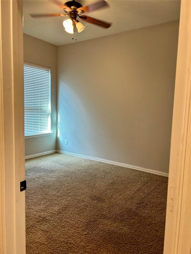 carpeted spare room featuring ceiling fan