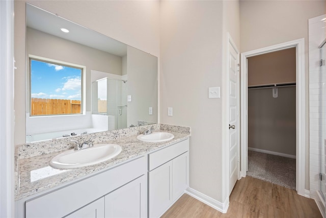 bathroom featuring hardwood / wood-style flooring, vanity, and separate shower and tub