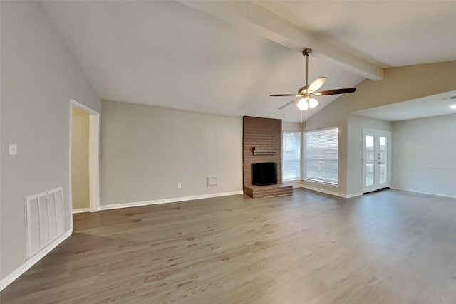 unfurnished living room featuring hardwood / wood-style floors, lofted ceiling with beams, ceiling fan, and a brick fireplace