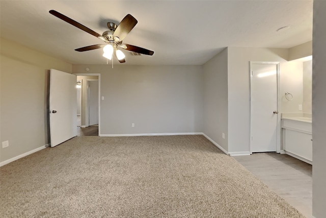 unfurnished bedroom featuring light carpet, ensuite bath, and ceiling fan