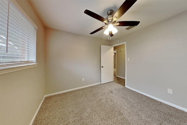 carpeted spare room with ceiling fan