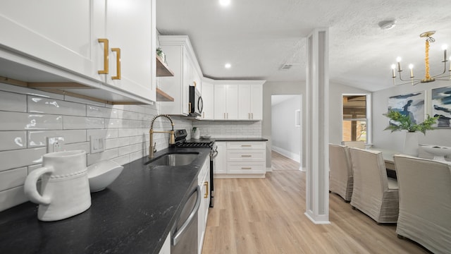 kitchen with sink, light hardwood / wood-style flooring, tasteful backsplash, white cabinetry, and stainless steel appliances