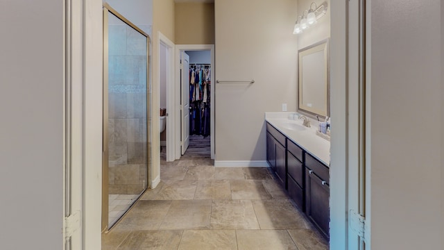 bathroom featuring toilet, vanity, and tiled shower