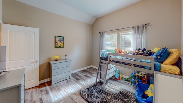 bedroom with light wood-type flooring and lofted ceiling