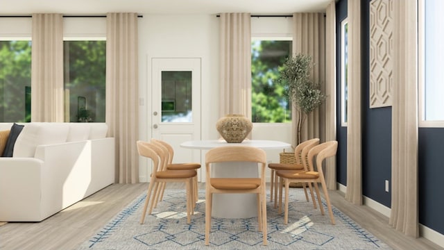 living area with a wealth of natural light and light hardwood / wood-style flooring