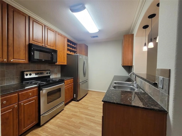 kitchen with sink, stainless steel appliances, tasteful backsplash, light hardwood / wood-style floors, and ornamental molding