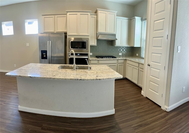 kitchen with a kitchen island with sink, sink, dark wood-type flooring, and appliances with stainless steel finishes