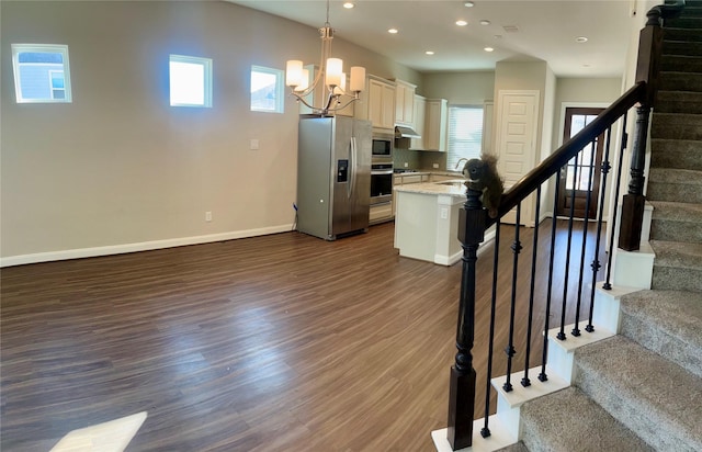 kitchen with appliances with stainless steel finishes, a center island, a wealth of natural light, and pendant lighting