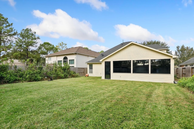 rear view of property featuring a lawn