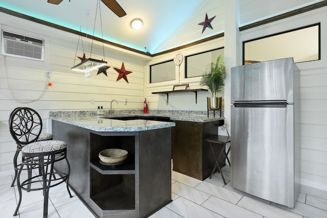 kitchen with vaulted ceiling, open shelves, freestanding refrigerator, and light stone countertops