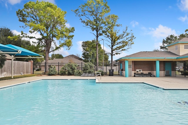 pool with a patio area and fence