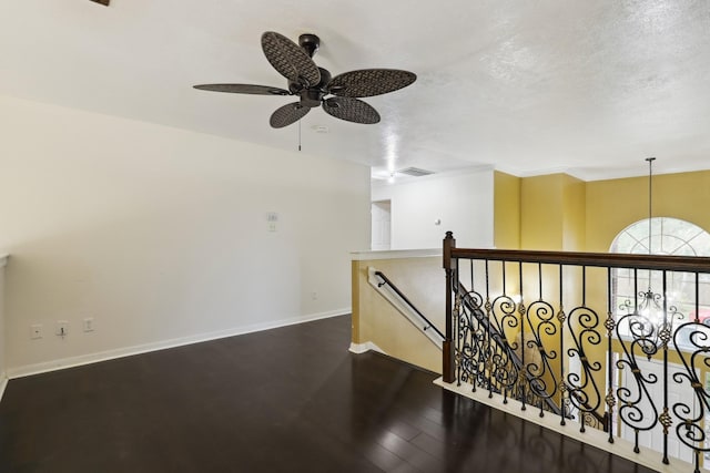 hall with a textured ceiling and dark wood-type flooring