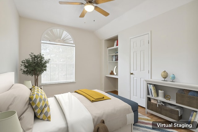 bedroom featuring a ceiling fan, multiple windows, vaulted ceiling, and wood finished floors