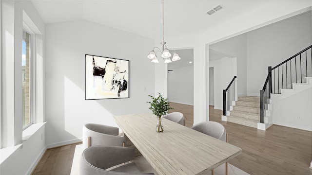 dining space with a healthy amount of sunlight, dark hardwood / wood-style floors, and an inviting chandelier