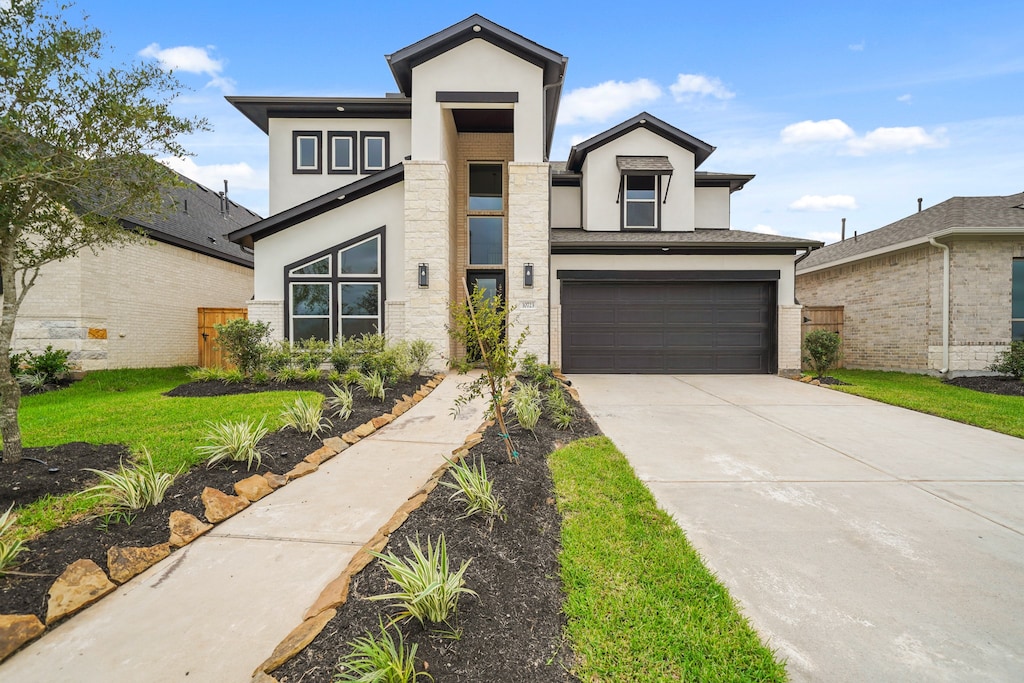 view of front of house with a garage and a front lawn