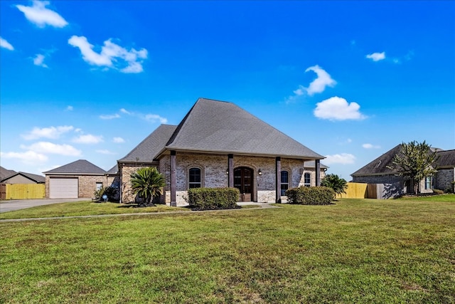 french country inspired facade featuring a garage and a front yard