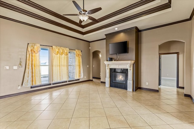 unfurnished living room with a raised ceiling, crown molding, and ceiling fan