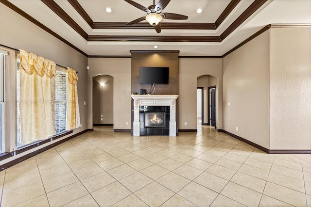 unfurnished living room featuring a tray ceiling, ceiling fan, light tile patterned floors, and ornamental molding